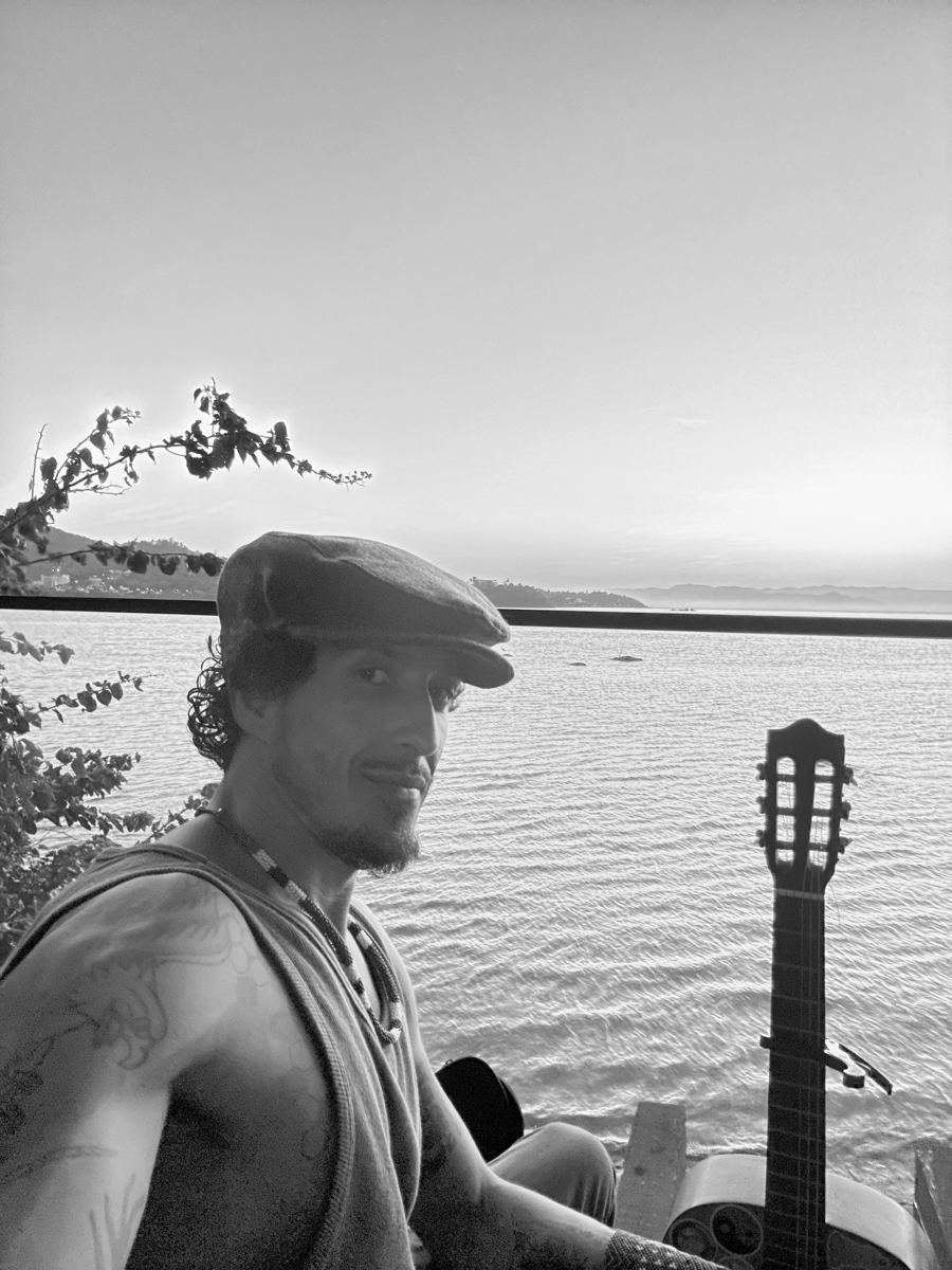 Guilherme Ribeiro ao pôr do sol, com o violão